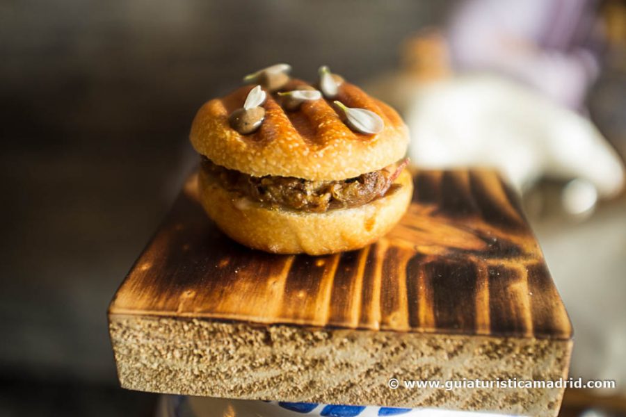 Bollo de leche de oveja con cuello guisado, torta de casar y ajo negro
